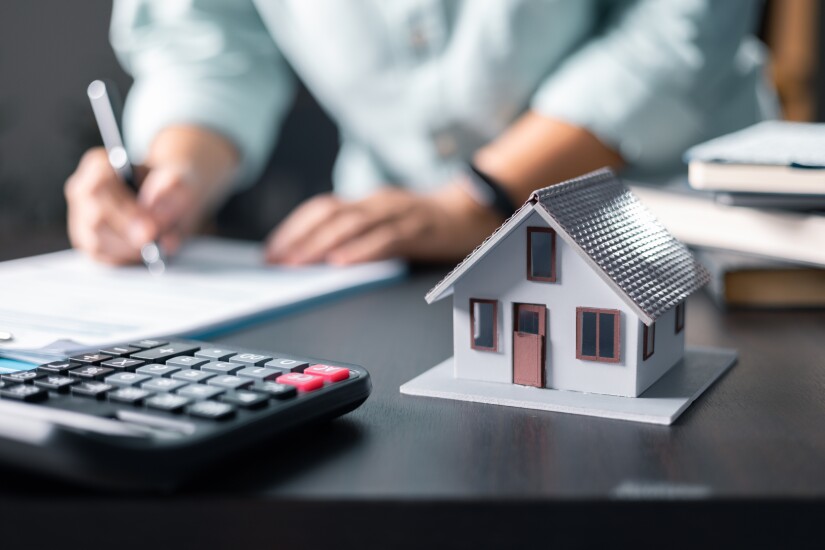 Mortgage property insurance dream moving home and real estate concept.Female calculate finance expenditures on machine, manage plan family household budget, insurance or loan real estate or property.