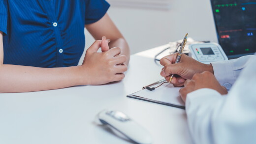 Doctor examining patient symptoms, providing healthcare advice in office, discussing diagnosis and treatment plan for wellness.