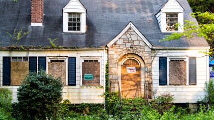Atlanta, USA - April 21, 2018: Old abandoned weathered wooden house with entrance and notice sign warning and company buying for cash and number