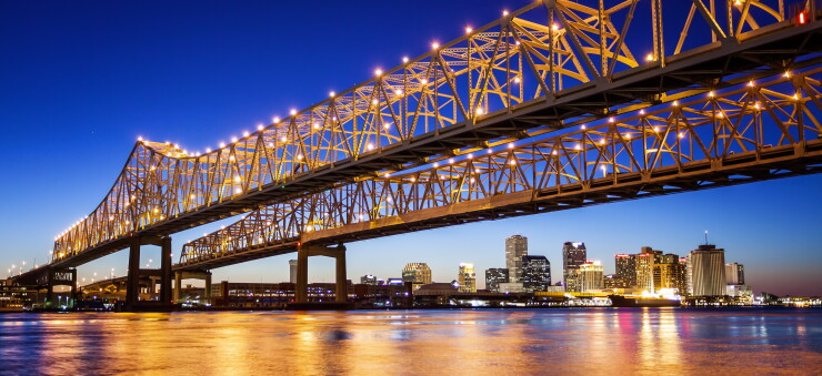 New Orleans city skyline and Crescent City connection bridge at night.