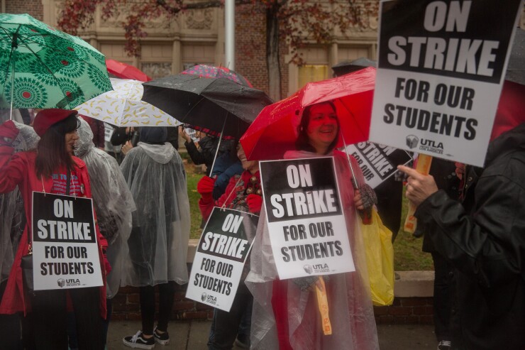 Teachers hold signs while marching a picket line during a teachers strike outside of John Marshall High School in Los Angeles, California, U.S., on Monday, Jan. 14, 2019.