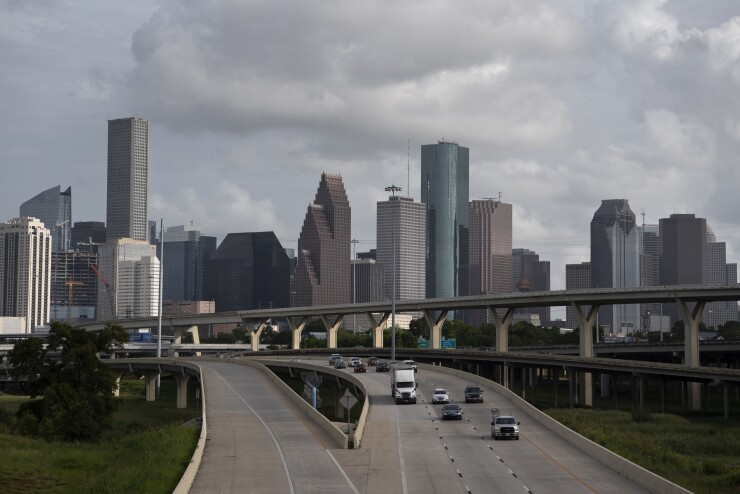 Traffic moves past the Houston skyline.