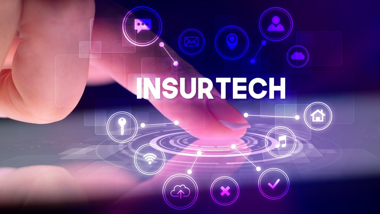 A person interacting with a screen with a holographic overlay that reads insurtech.