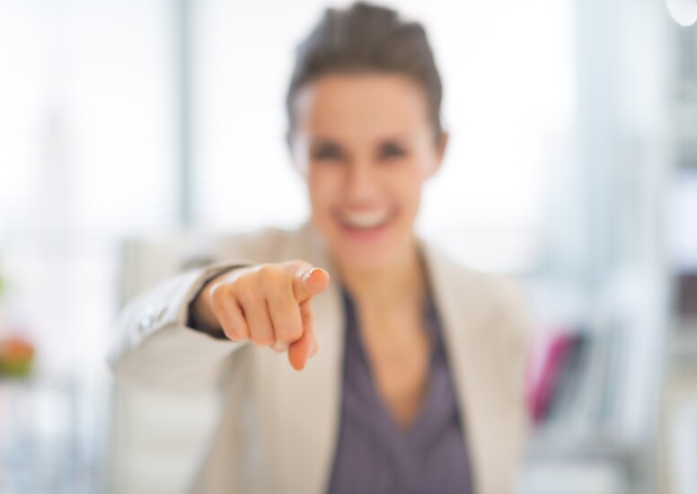 Closeup of happy businesswoman pointing at camera