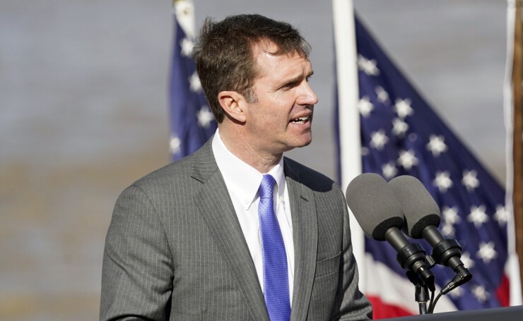 Kentucky Gov. Andy Beshear speaking at a podium