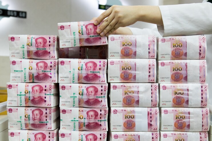 An employee arranges genuine bundles of Chinese one-hundred yuan banknotes at the Counterfeit Notes Response Center of KEB Hana Bank in Seoul, South Korea.