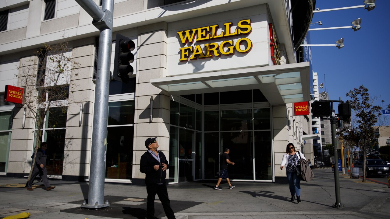 Pedestrians walk past a Wells Fargo bank branch in Los Angeles on Thursday, April 19, 2018.