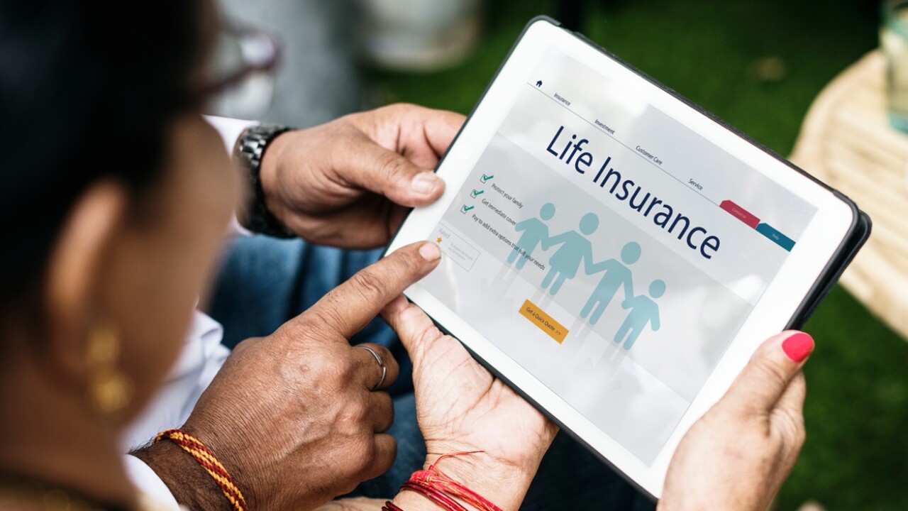 Person holding a tablet and looking at a life insurance form.