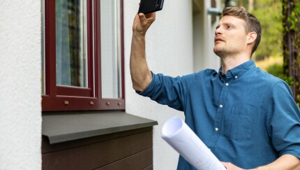 real estate appraiser taking pictures of property with phone
