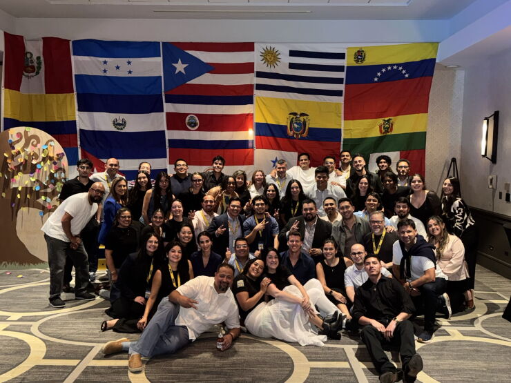 Attendees who were part of a group of 140 financial advisors and other wealth management professionals at last year's SER conference posed in front of a display of flags at the event.