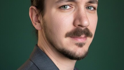 A man in dress clothes posing for a photo.