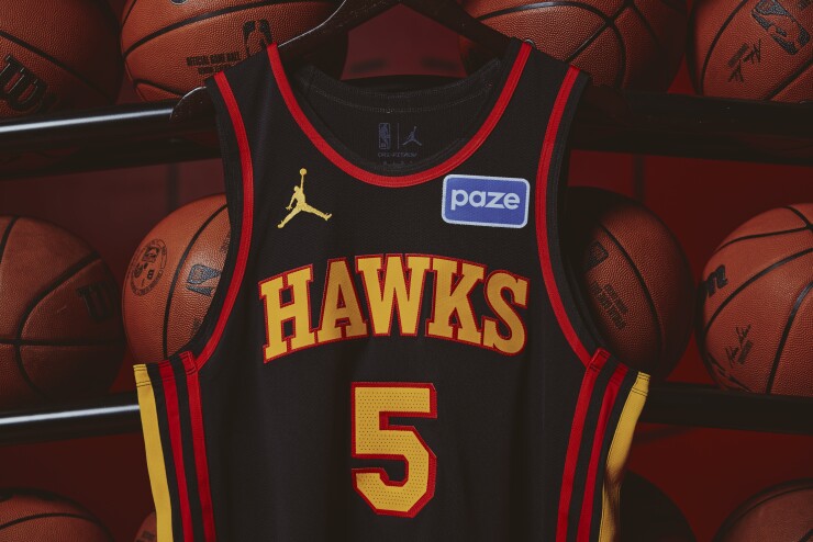 An Atlanta Hawks jersey with a Paze patch in front of basketballs.