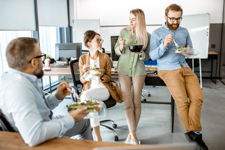 Group of employees eating healthy at work