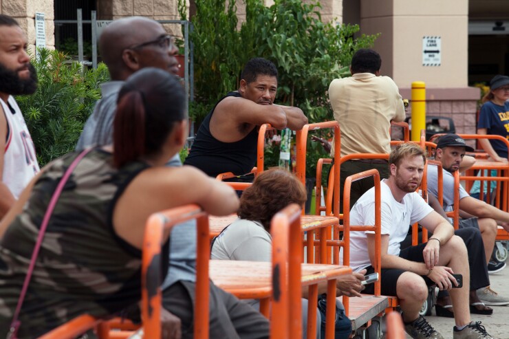 Customers wait in line at a Home Depot Inc. store ahead of Hurricane Irma in Miami.