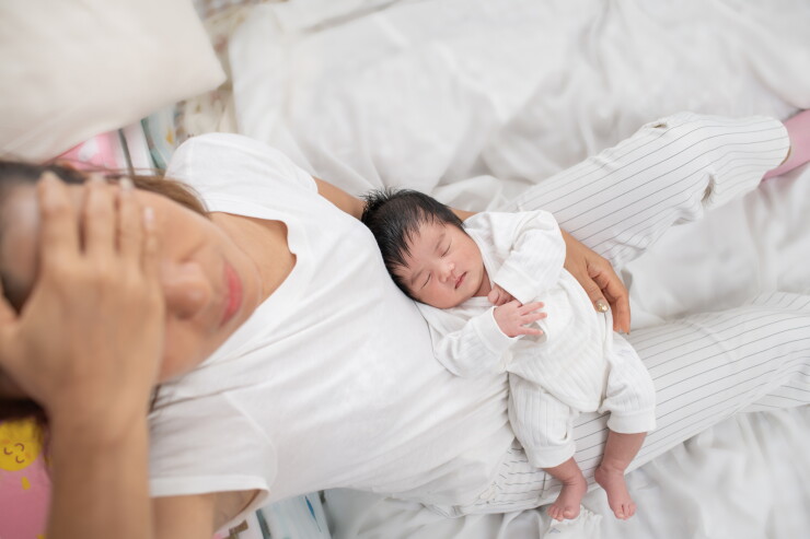 Woman looking stressed while holding her baby