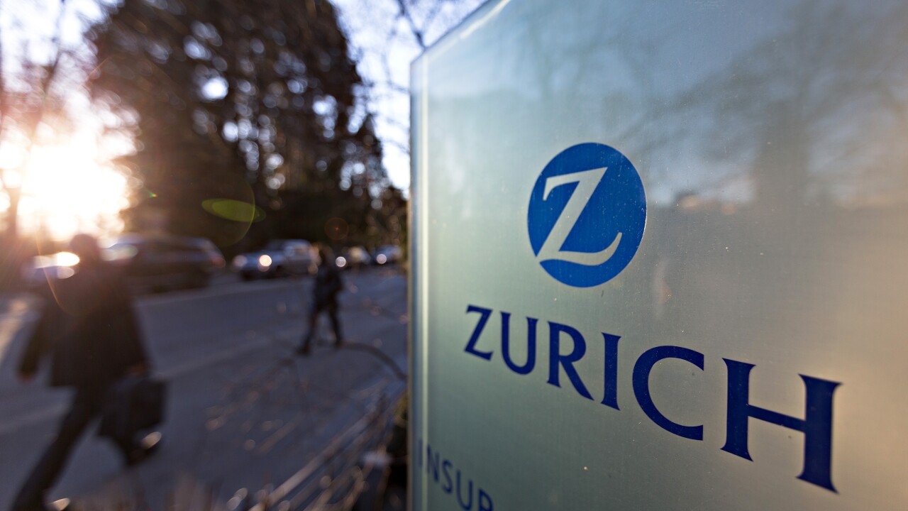 A sign that reads Zurich with blurred people walking in the background