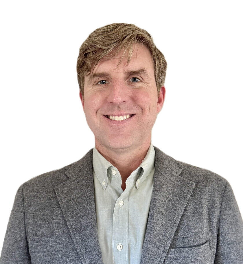 A man smiling for a portrait photo.