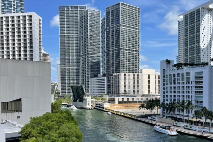 A Miami scene including a pleasure boat, a drawbridge and tall buildings.
