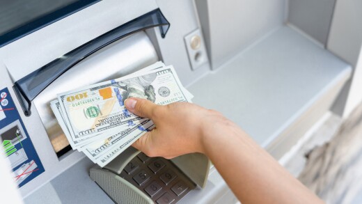 Hand taking cash from an ATM