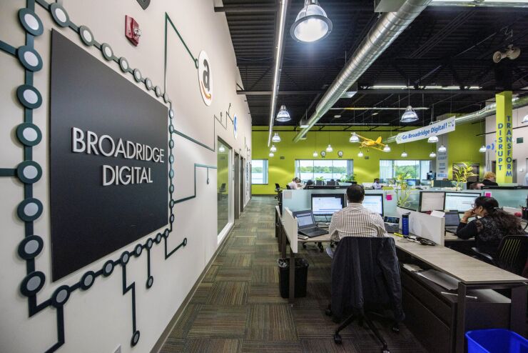Employees work at computers at the Broadridge Financial Solutions digital office in Brentwood, New York