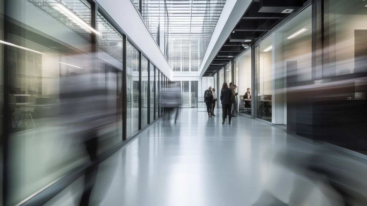 An office floor with blurred people walking.