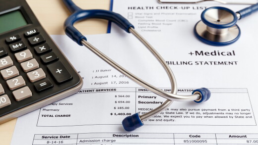 Medical cost concept with calculator and stethoscope.
