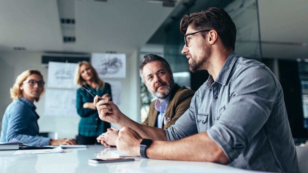 Male employee speaking to group in conference room