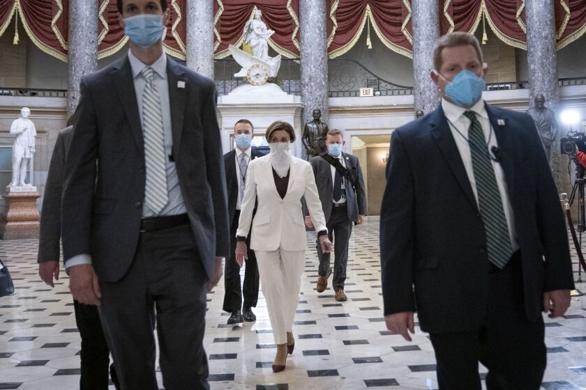 Lawmakers enter the House chamber wearing protective masks.