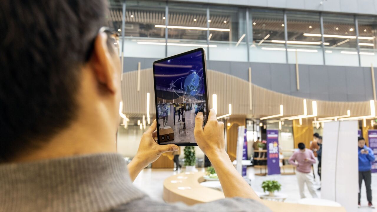 An employee uses a tablet to demonstrate an augmented reality (AR) application in an atrium at the SenseTime Group Inc. headquarters in Shanghai, China, on Friday, Dec. 3, 2021. Chinese artificial intelligence giant SenseTime rose on its first day of trading in Hong Kong after a rocky initial public offering that was delayed by concerns over fresh U.S. sanctions. Photographer: Qilai Shen/Bloomberg