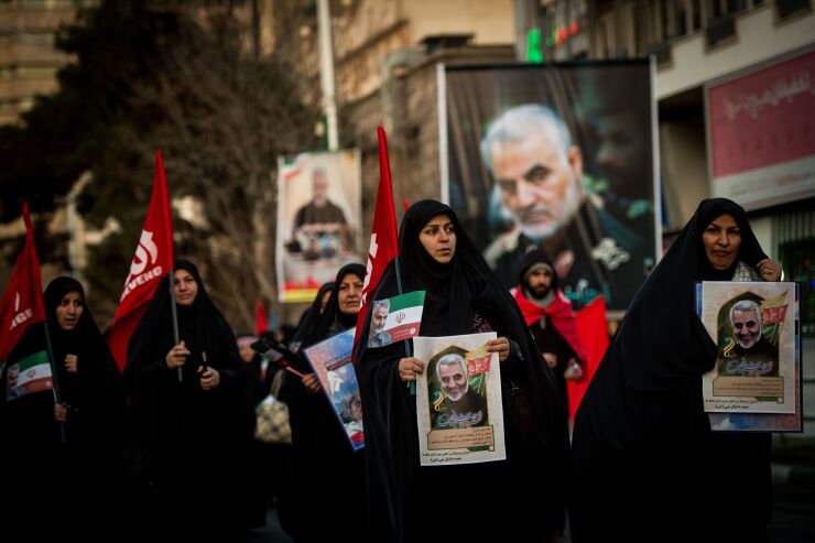 Mourners carry images of Iranian General Qassem Soleimani during the funeral ceremony in Tehran, Iran, on Monday, Jan. 6, 2020.