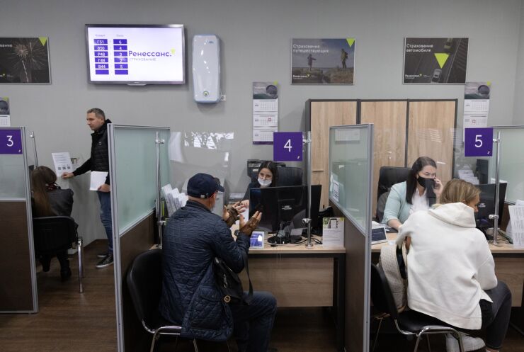 Employees speak with customers between protective screens inside a Renaissance Insurance customer service center in Moscow, Russia, on Wednesday, Sept. 15, 2021. A Russian insurance company backed by billionaire Roman Abramovich has picked banks to prepare it for an initial public offering, according to two people familiar with the matter.