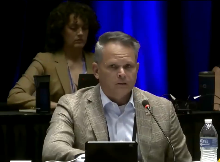 Trinidad Navarro, Delaware insurance commissioner, seated at microphone