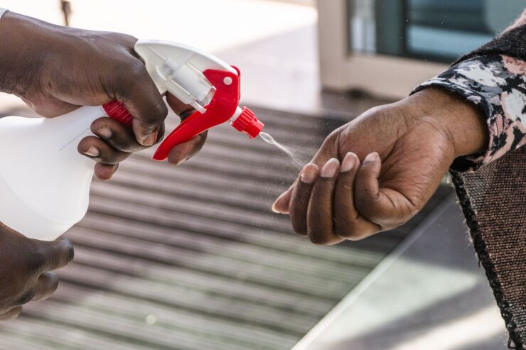 A worker sprays sanitizer into the hands of a shopper at a supermarket in Johannesburg, South Africa in May.