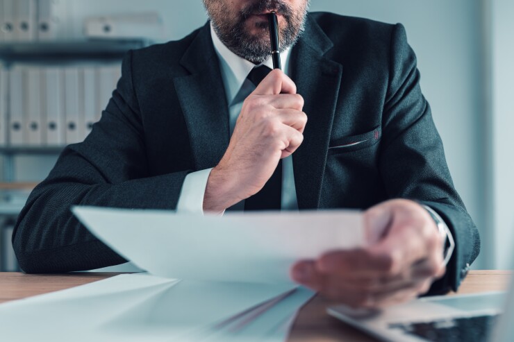 Fiduciary, agent carefully reading business papers in office