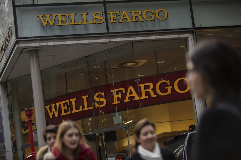 Pedestrians pass in front of a Wells Fargo branch in New York.