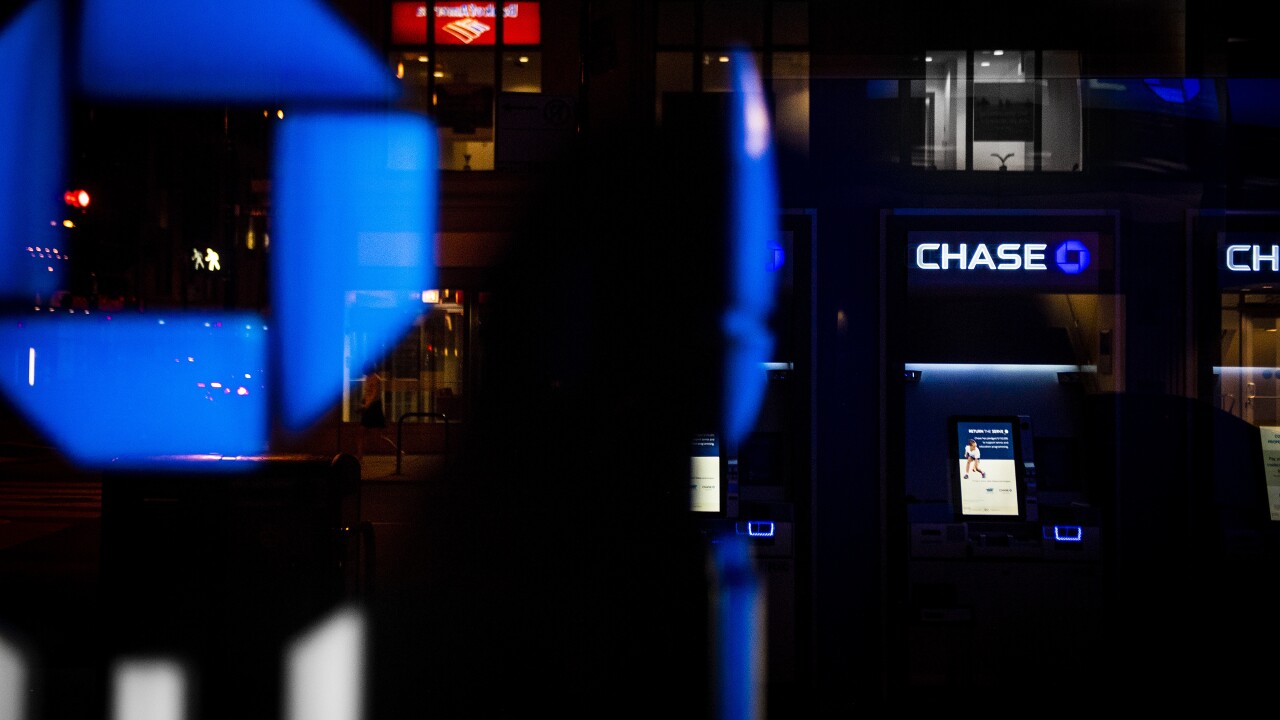 JPMorgan Chase signage and ATMs are illuminated at night at a bank branch in Chicago.
