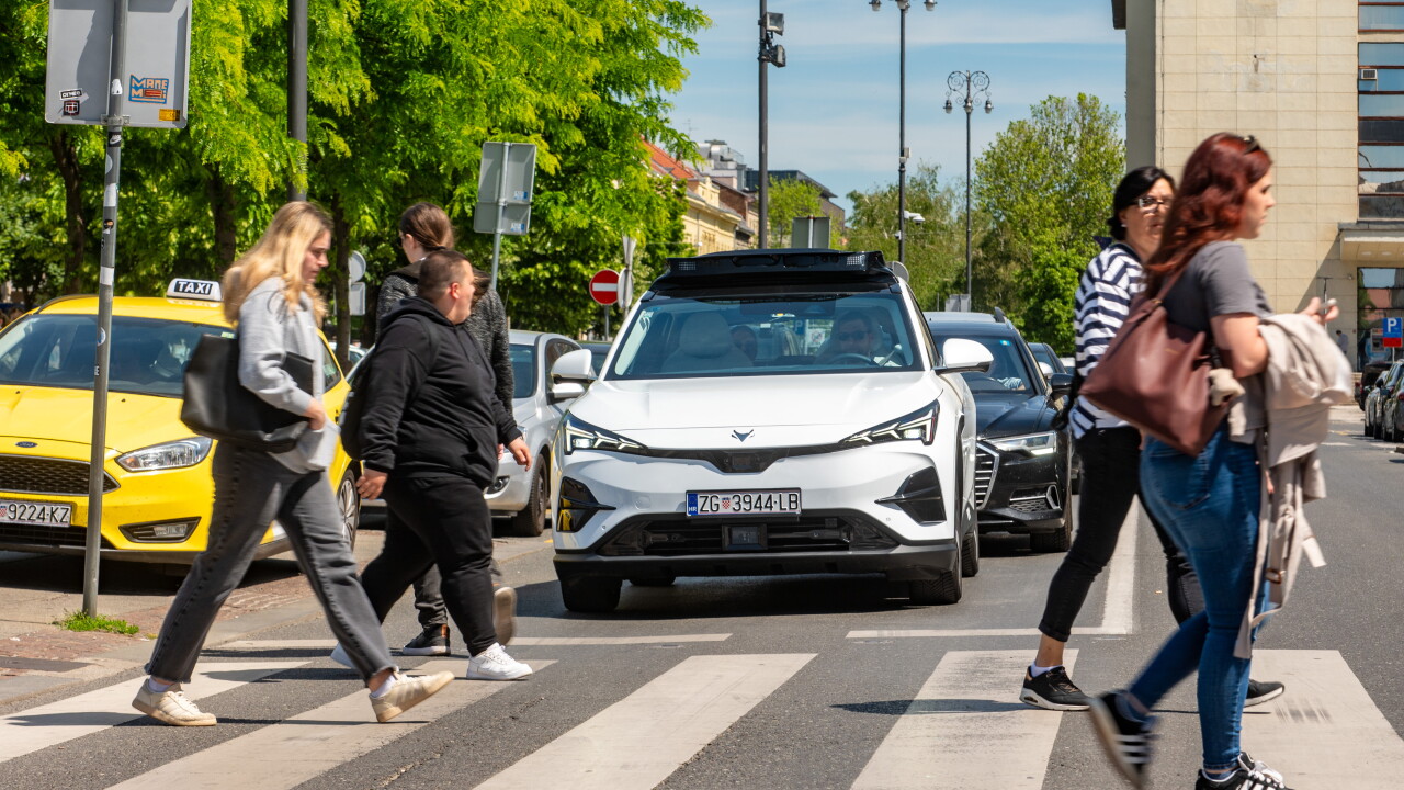 Pedestrians crossing intersection in front of robotaxi