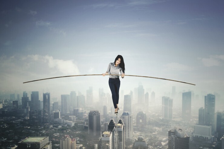 Risk concept -- woman on tightrope