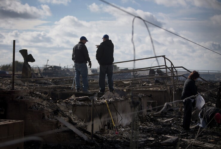 Residents look over the damage to their home in the Breezy Point neighborhood of the Queens borough of New York, U.S., on Wednesday, Oct. 31, 2012.