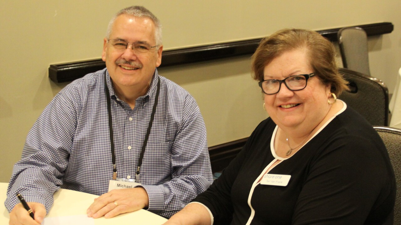 Michael Hinchey, president and CEO of Wepawaug Flagg FCU in Hamden, Conn., signing his Share One contract renewal at the October 2018 SYNC conference with Share One President and CEO Teri Van Frank.
