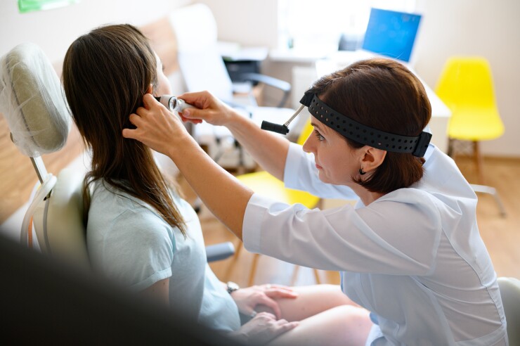 Doctor examining girl's ear