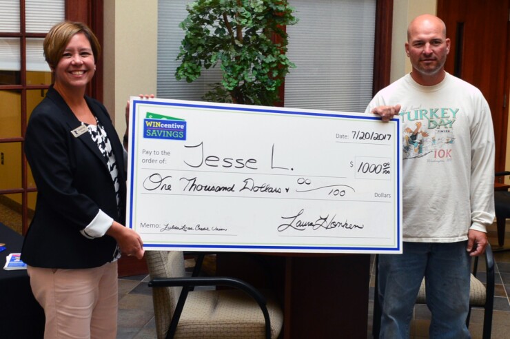 Andrea Molnau, director of communications for the Minnesota Credit Union Network, presents a check to a recent WINcentive Savings quarterly drawing prize winner.
