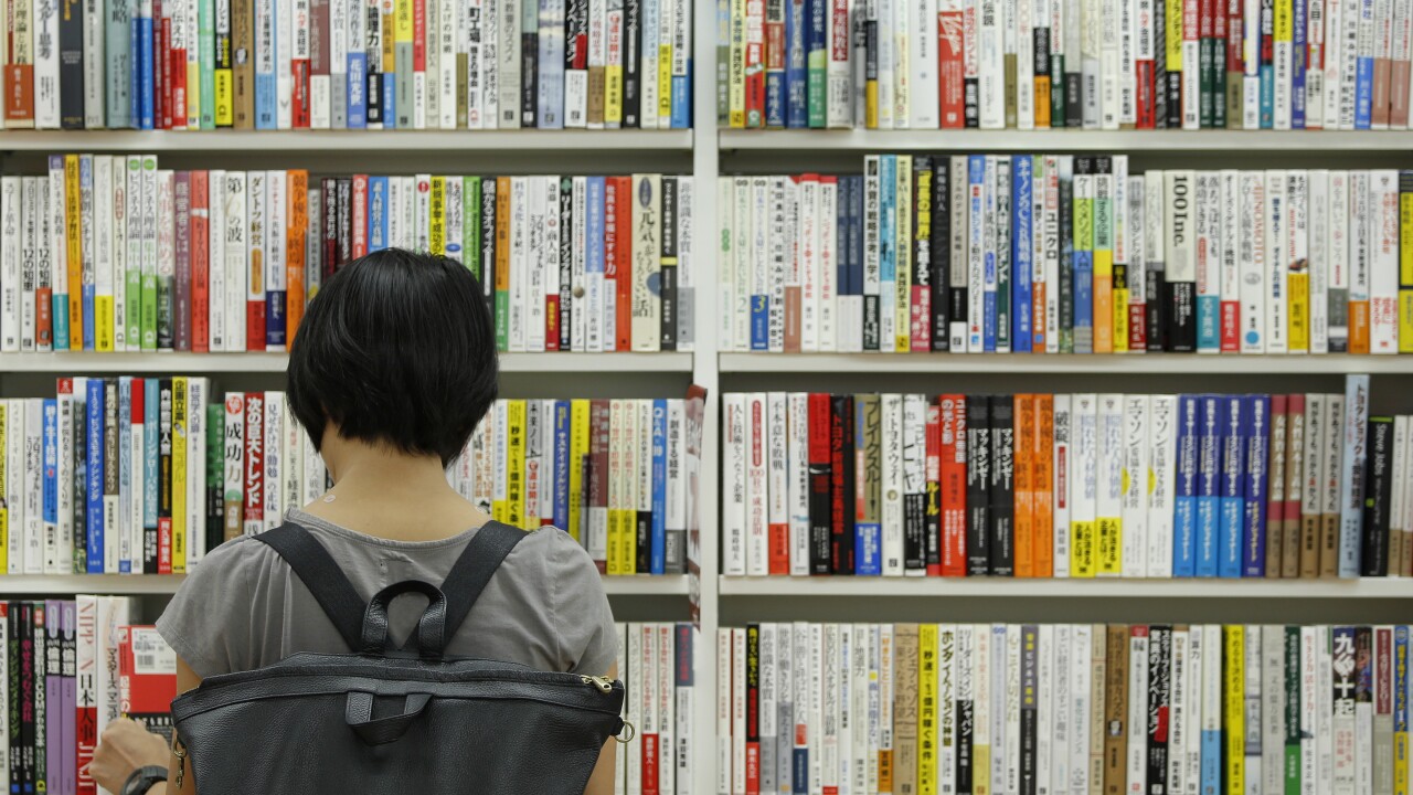A customer browses second-hand books in a Japanese bookstore
