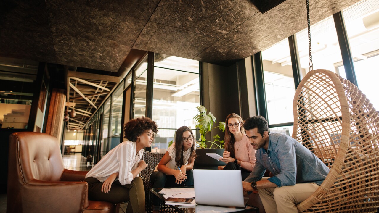Creative business team using laptop during meeting