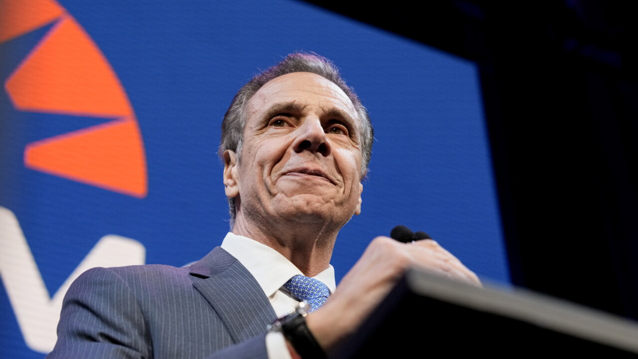 Andrew Cuomo smiles at a podium.