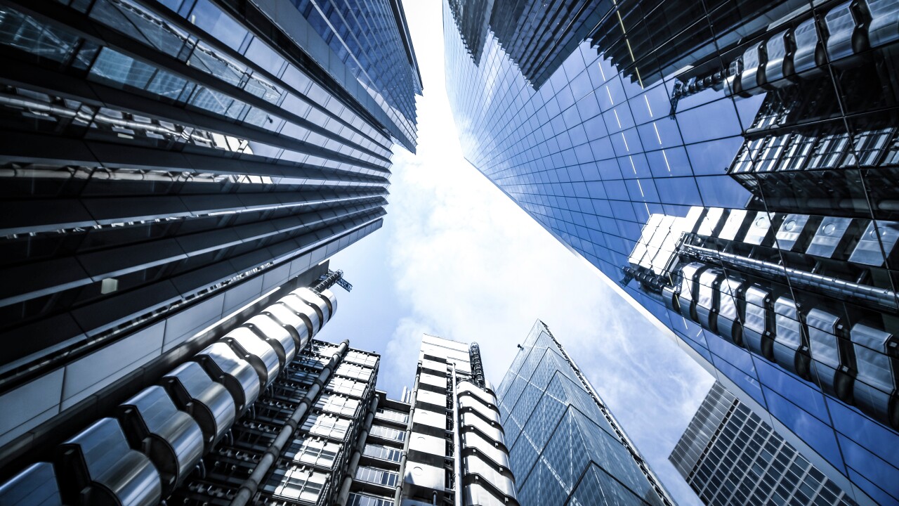 Looking up at the sky with large building around.