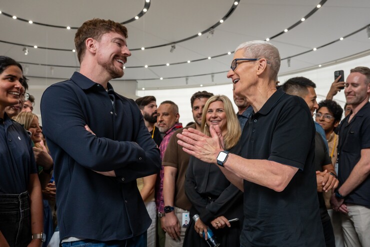 MrBeast on left and Tim Cook on right facing each other and talking in a crowd