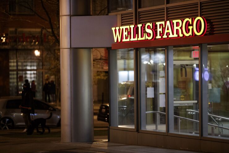 Signage outside a Wells Fargo bank branch at night in Washington