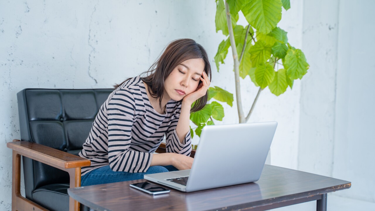 Woman falling asleep at work.