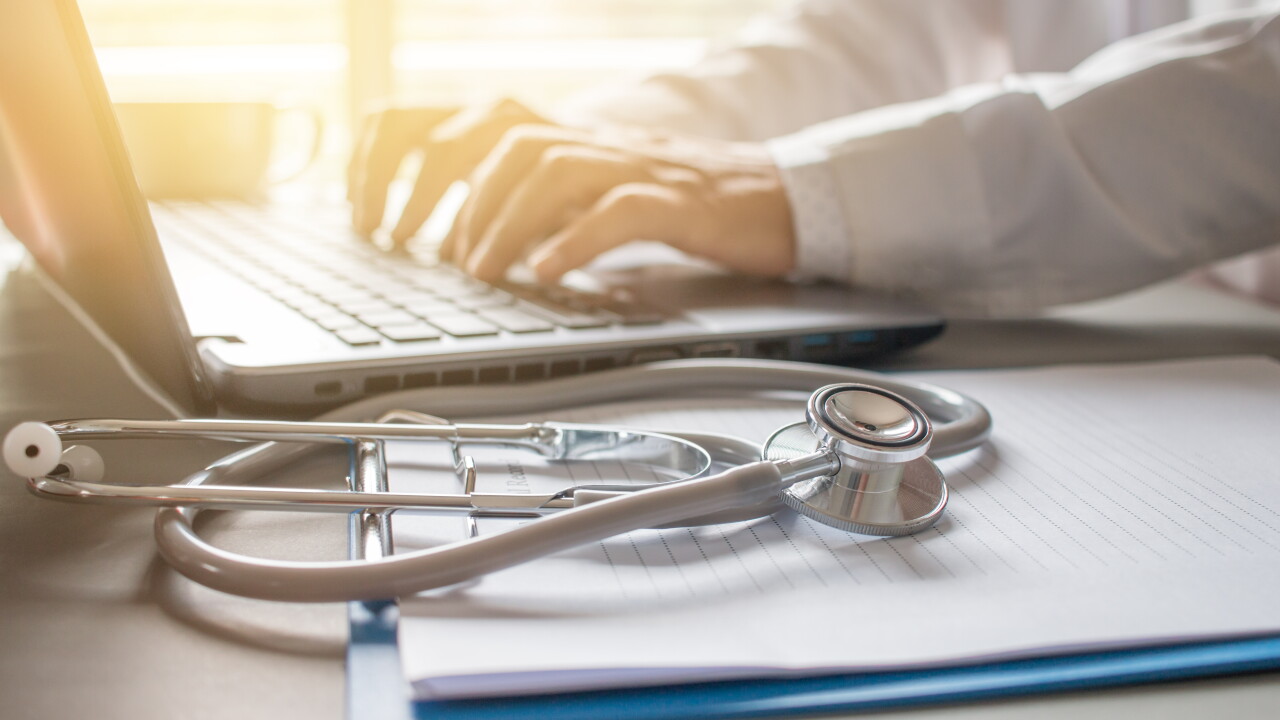 A medical professional types on a keyboard.